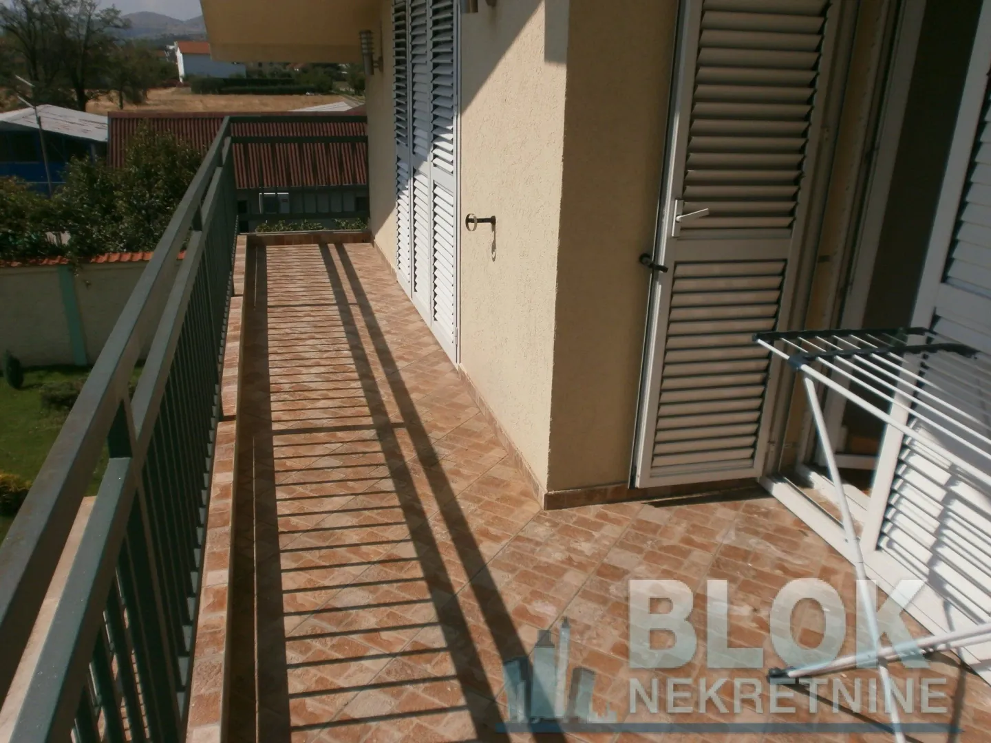 Spacious terrace with tiled floor and railing.