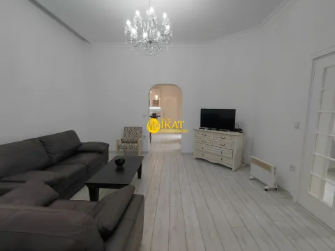 Spacious living room with a seating set, television, and a view of the hallway. - image 11