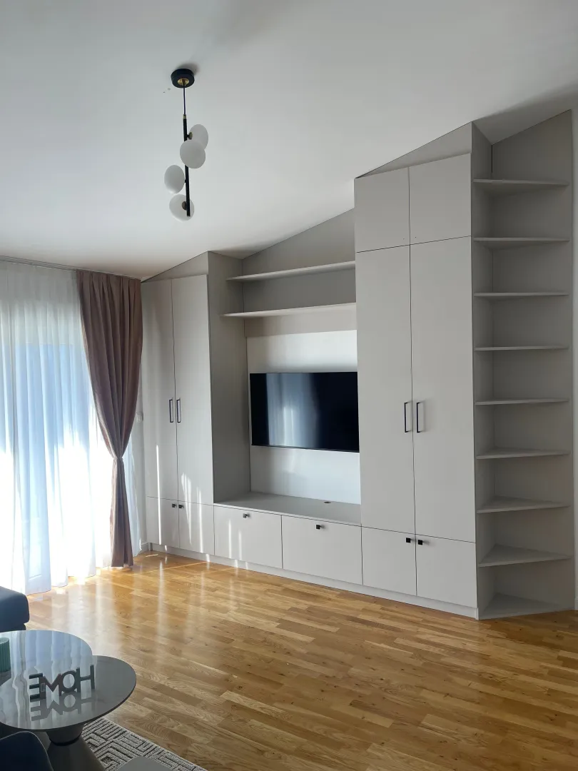 Dnevna soba sa ugradnim plakarima i televizorom.
