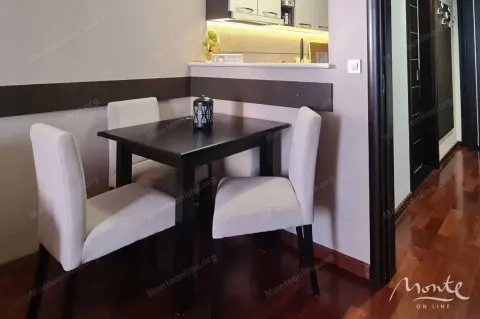 Dining nook with a black table and upholstered chairs near the kitchen counter. - image 10
