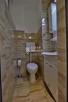Manje kupatilo obloženo keramičkim pločicama sa ugradnim toaletom i umivaonikom. - image 12