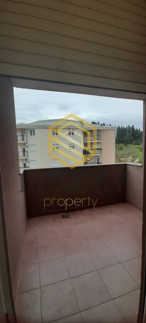 Empty tiled terrace with a view of the neighboring building.