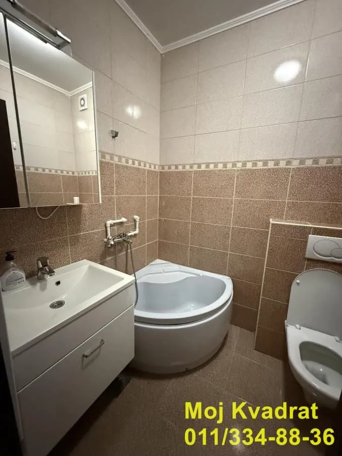 Manje kupatilo sa umivaonikom, ugradnom kadom i wc šoljom.