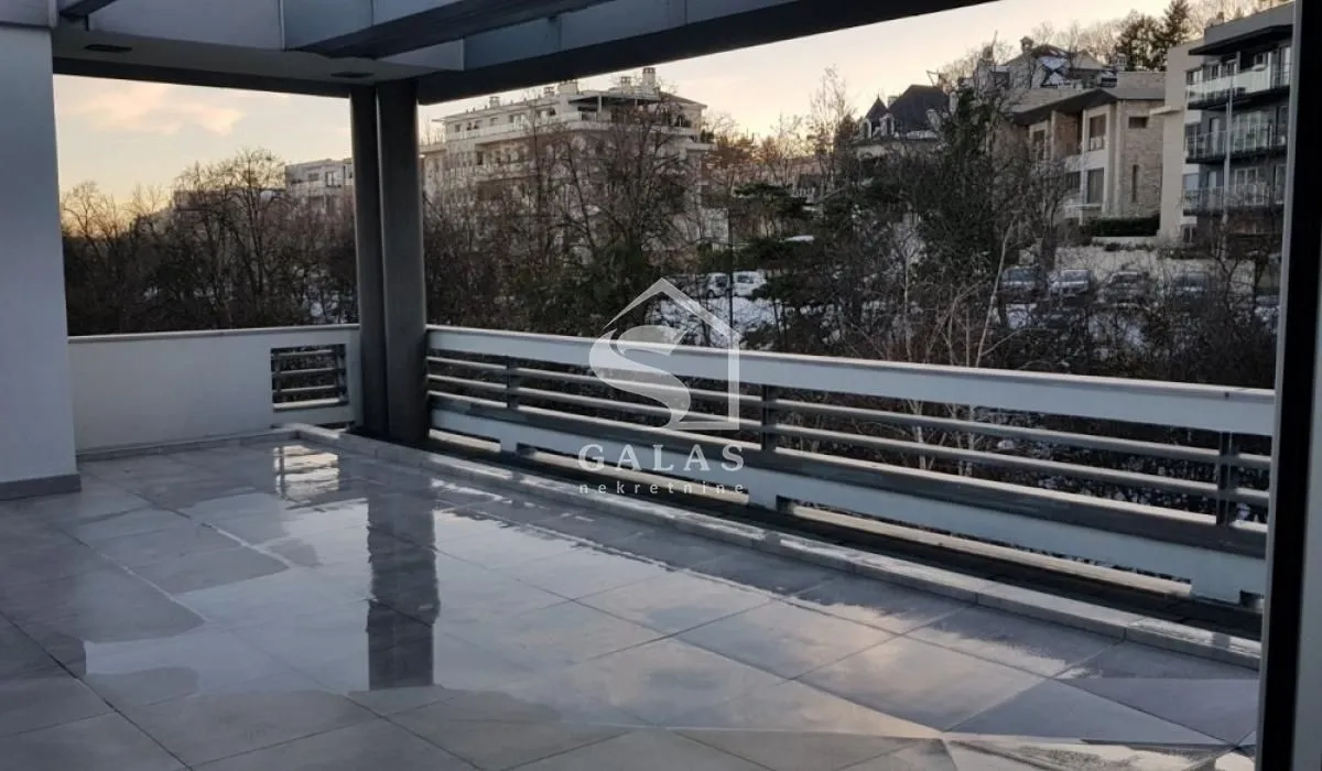 Spacious covered terrace with a view of surrounding buildings and nature.