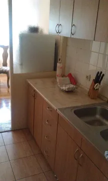 A simple kitchen with wooden cabinets and a sink. - image 3