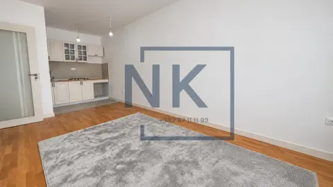 Dnevna soba sa manjom kuhinjom i drvenim podom. - image 3