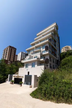 Pogled na spoljašnjost moderne stambene zgrade sa terasama i uređenim ulazom. - image 25