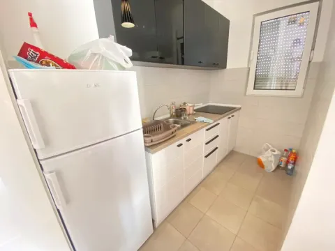 Manja kuhinja sa bijelim elementima, frižiderom i crnim gornjim ormarićima. - image 5