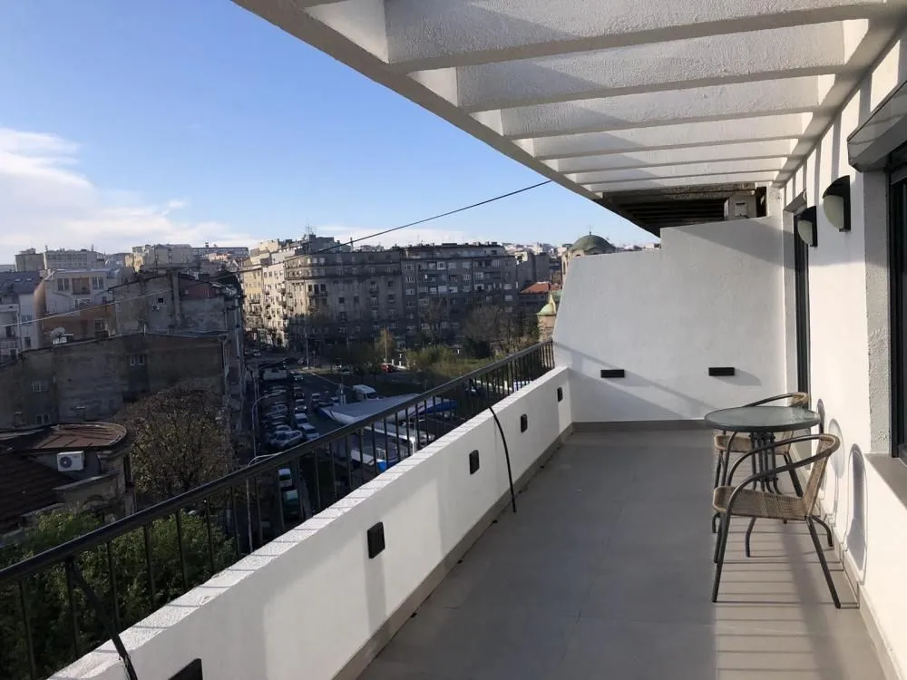 Spacious balcony with outdoor seating and a city view.