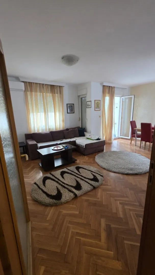 Bright living room with a corner sofa and parquet flooring.