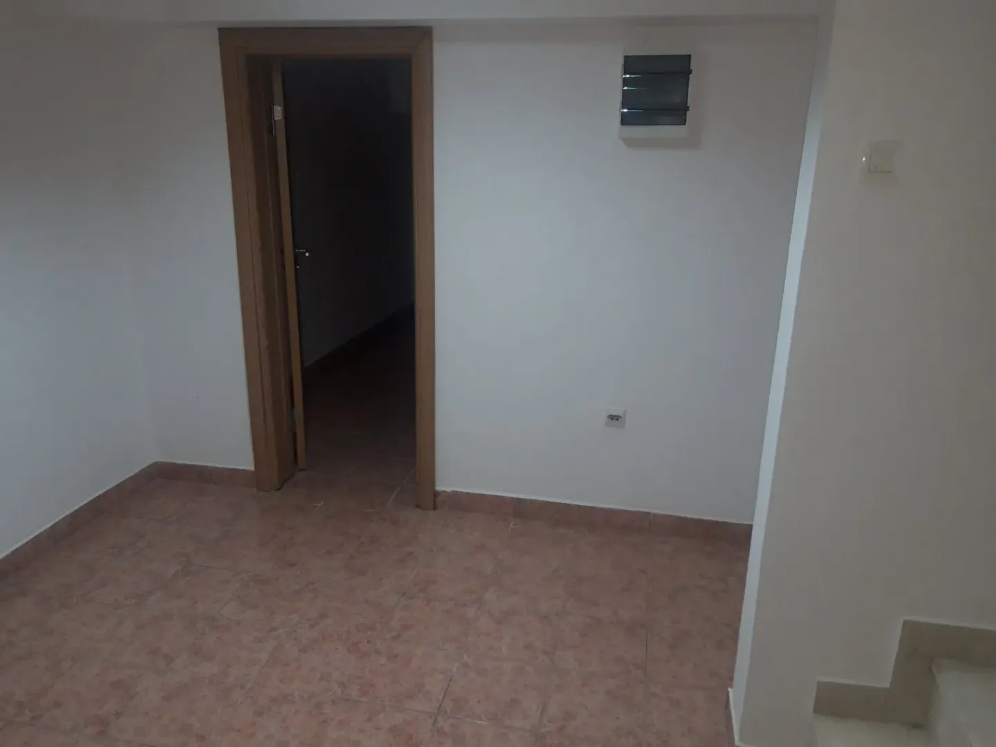 An empty room with tiled flooring and an open doorway.