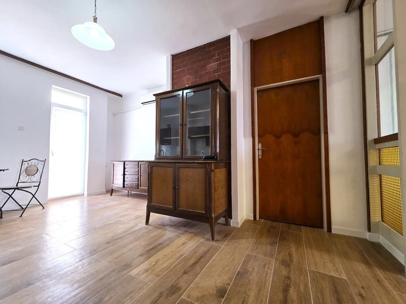 Spacious living room with wooden furniture and parquet flooring.