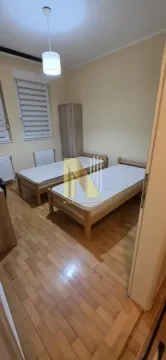 Spavaća soba sa dva drvena kreveta i ormarom. - image 7