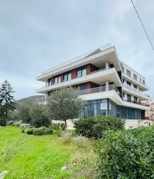 Pogled na spoljašnjost moderne stambene zgrade sa uređenim dvorištem. - image 5