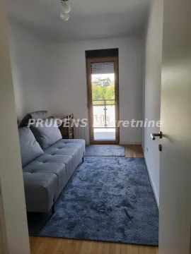 Manja dnevna soba sa sivom sofom i izlazom na terasu. - image 8