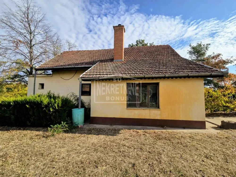 Pogled na zadnju stranu kuće i dvorište sa travnjakom.