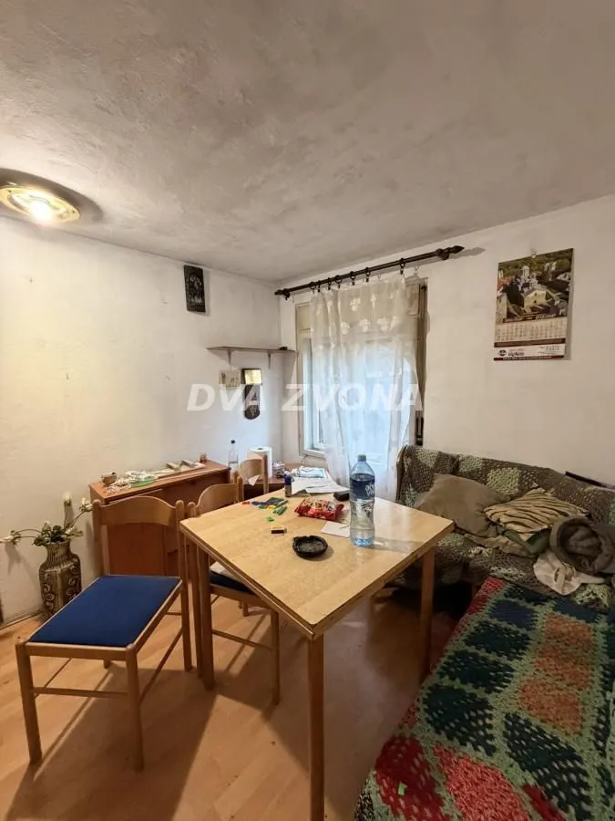 Manja dnevna soba sa trpezarijskim stolom i kaučem.