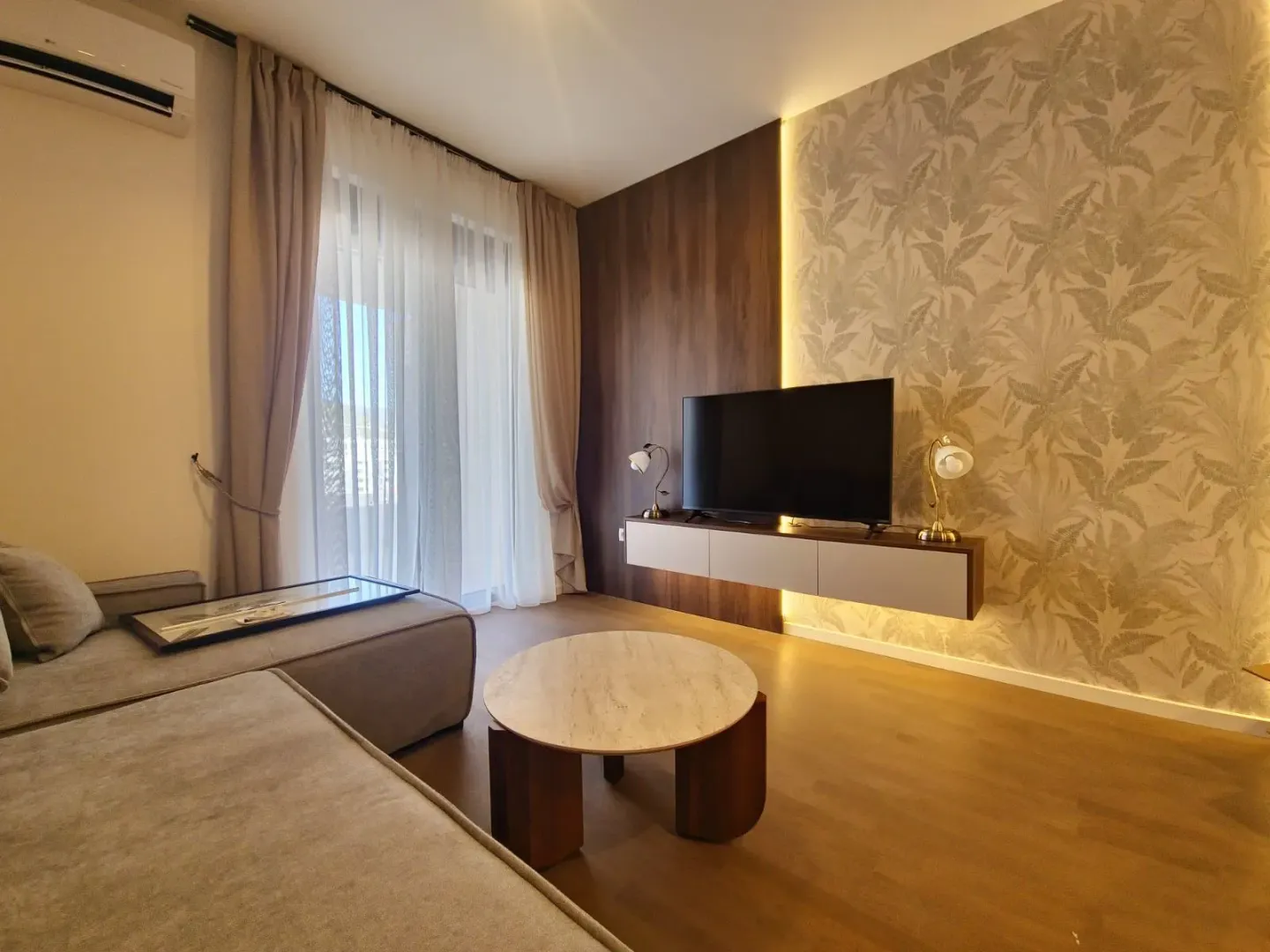 Living room with sofa, TV and access to the terrace.