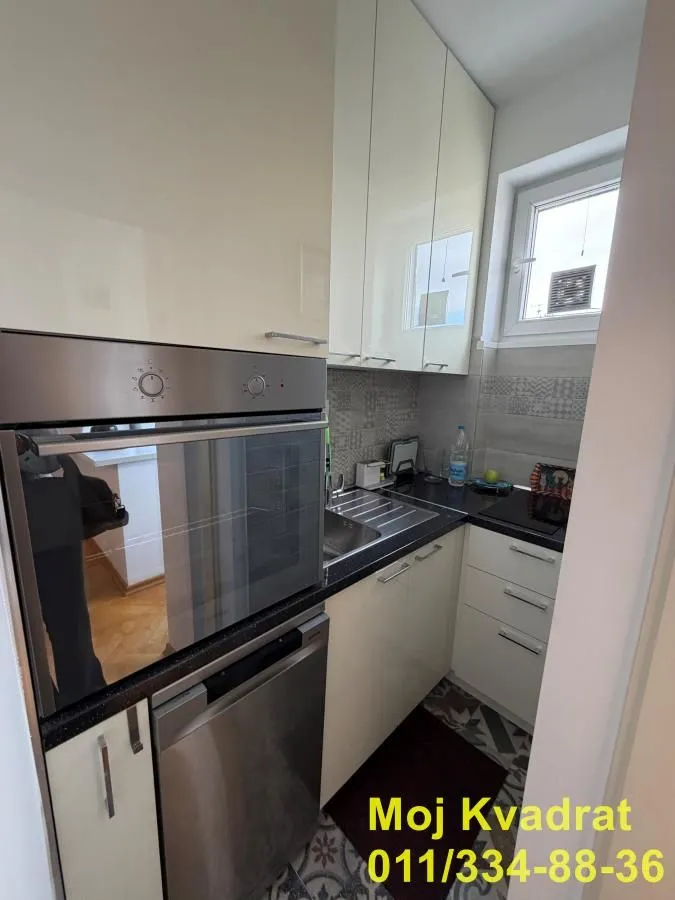Small equipped kitchen with built-in units and appliances.