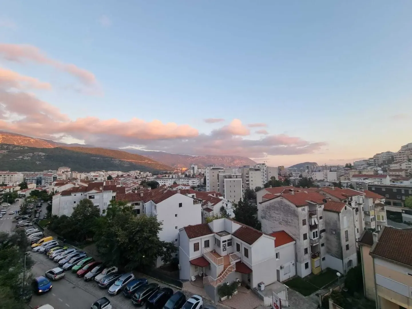 Pogled sa terase na grad i planine u pozadini.