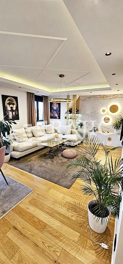 Modern and bright living room with a sofa and hardwood flooring.
