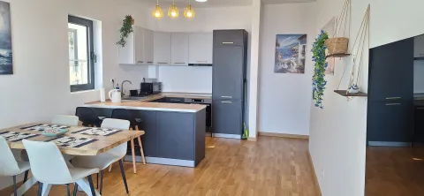 Modern kitchen with a bar counter and dining table. - image 3