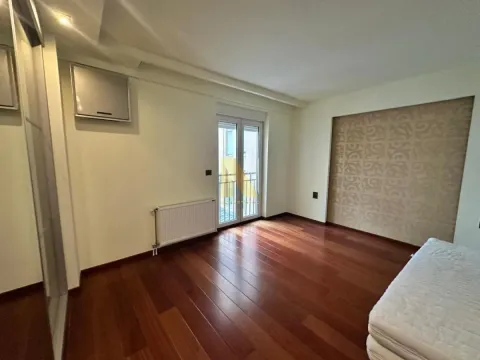 Prazna spavaća soba sa drvenim podom i balkonskim vratima. - image 8