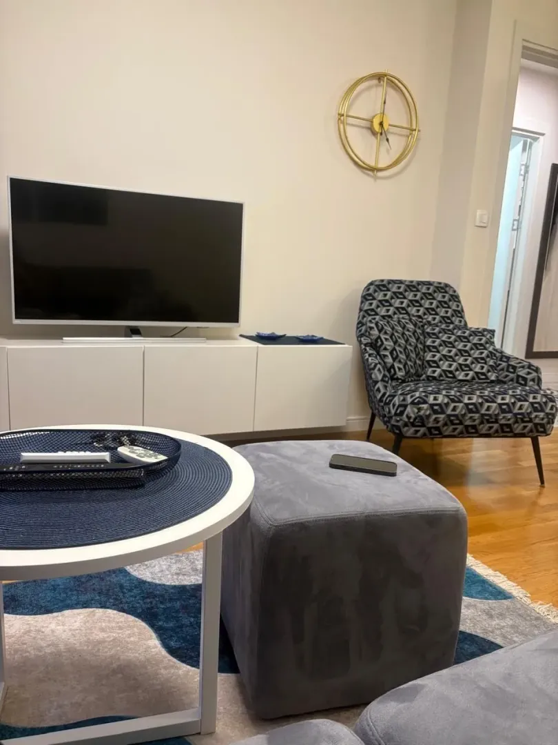 Living room with a TV, armchair, and coffee table.