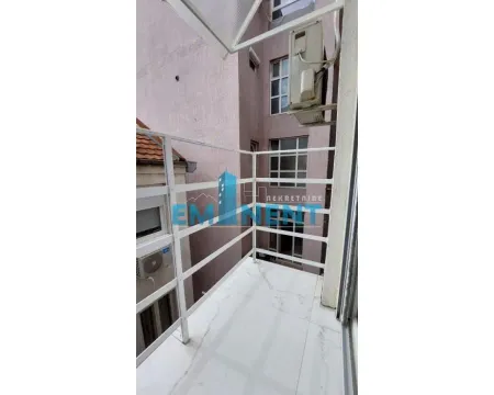 Small balcony with a white railing and a view of the neighboring building. - image 13
