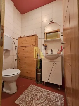 Manje kupatilo sa sanitarijama, umivaonikom i drvenim ormarićem. - image 9