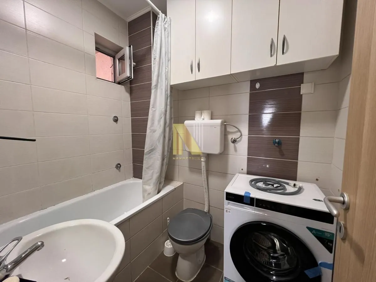 Kupatilo opremljeno kadom, sanitarijama i veš mašinom.