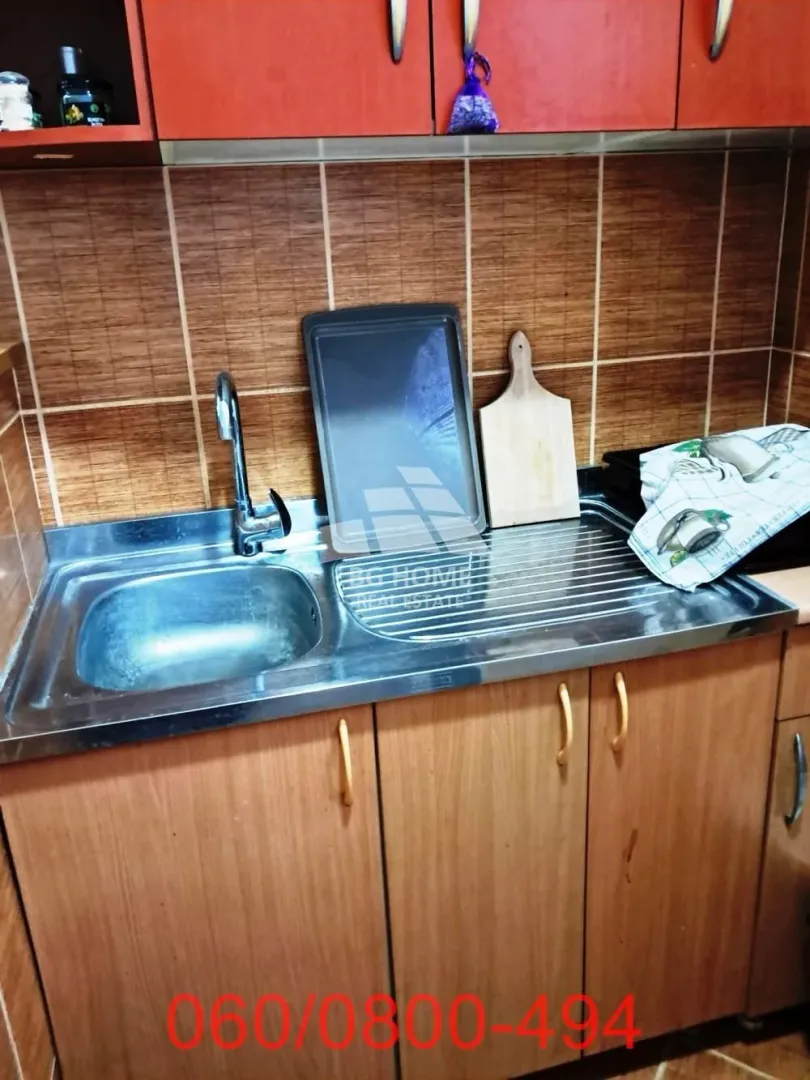 Pogled na sudoperu i donje kuhinjske elemente sa radnom površinom.