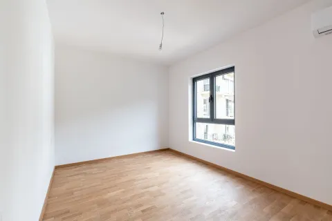 Prazna soba sa bijelim zidovima, parketom i jednim prozorom. - image 9