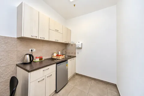 Small kitchen with a sink, refrigerator, and light-toned cabinets. - image 4