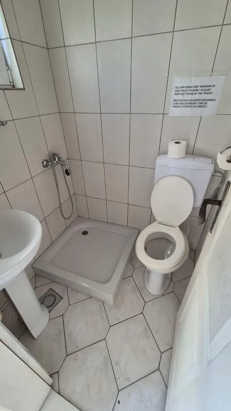 Small bathroom with a shower cabin, washbasin, and toilet.