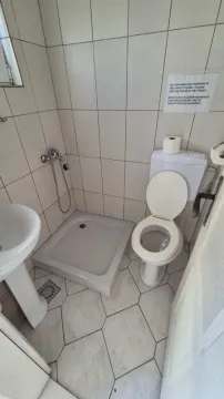 Small bathroom with a shower cabin, washbasin, and toilet. - image 12