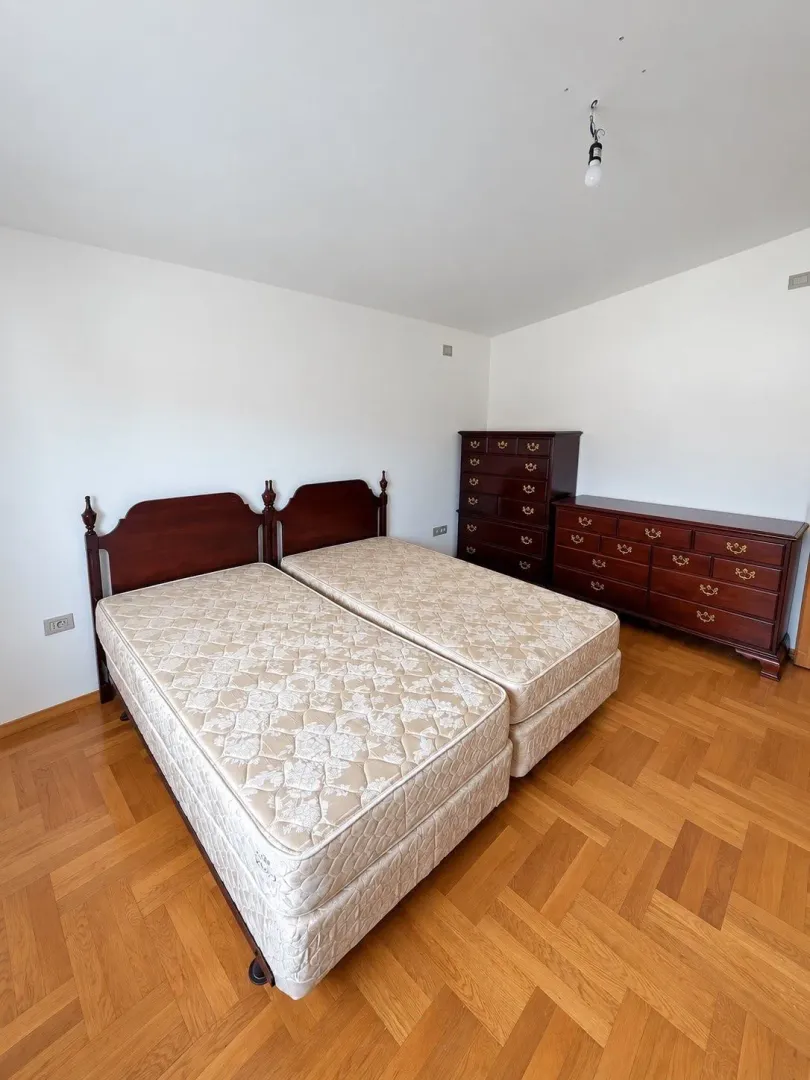 Bedroom with two beds and a wooden dresser.