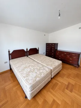 Bedroom with two beds and a wooden dresser. - image 2
