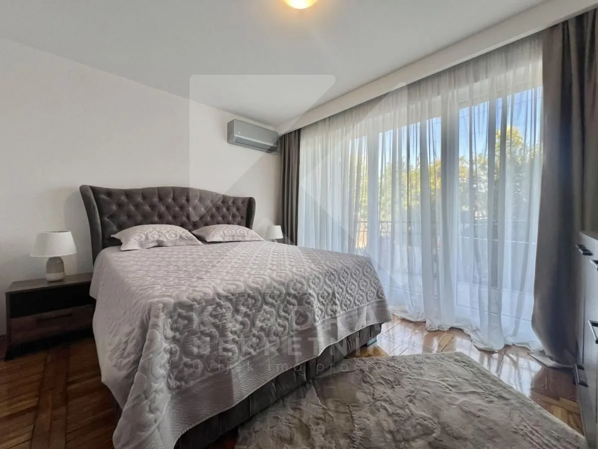 Spacious bedroom with a double bed and large balcony doors.
