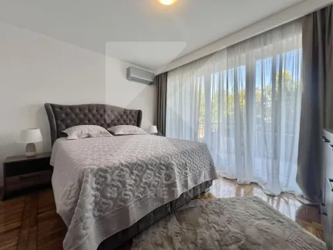 Spacious bedroom with a double bed and large balcony doors. - image 5