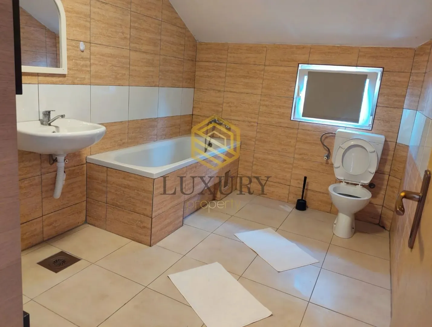 Small bathroom with a bathtub, sink, and toilet.