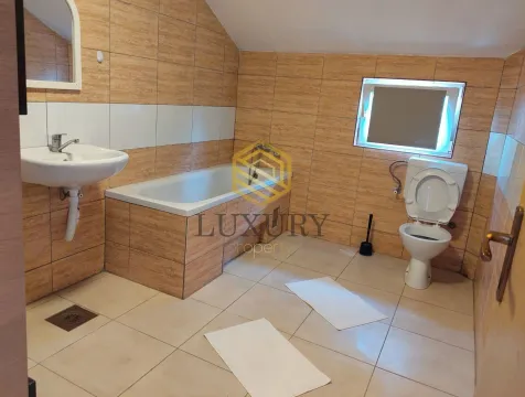 Small bathroom with a bathtub, sink, and toilet. - image 6