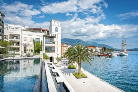 View of the building with a swimming pool and the marina promenade with boats. - image 15