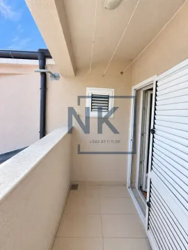 Small covered balcony with ceramic tiles and a door with shutters. - image 9