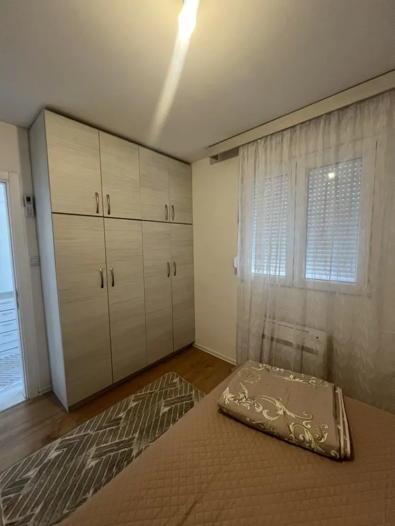 A bedroom with a wardrobe and window.