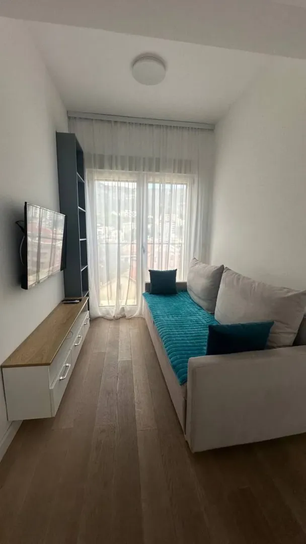 Smaller living room with a sofa, TV, and access to the terrace.