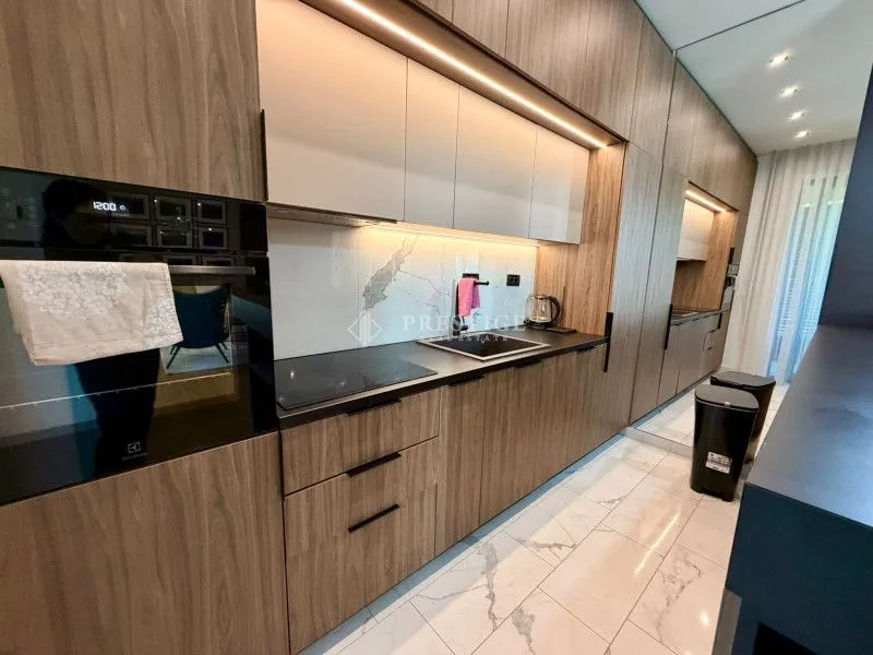 Modern kitchen with wooden cabinetry and built-in appliances.