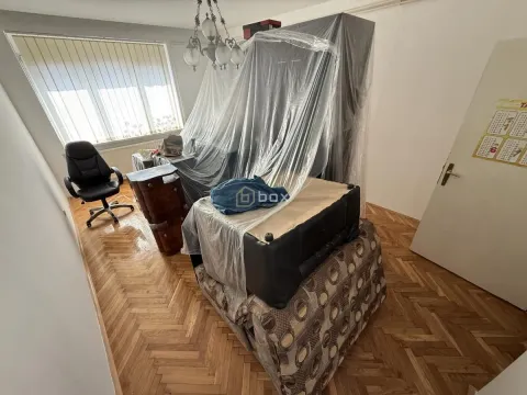 Dnevna soba sa nameštajem prekrivenim najlonom i parketom na podu. - image 4