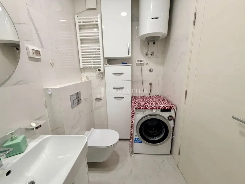 Modernly equipped bathroom with sanitary fixtures and a washing machine.