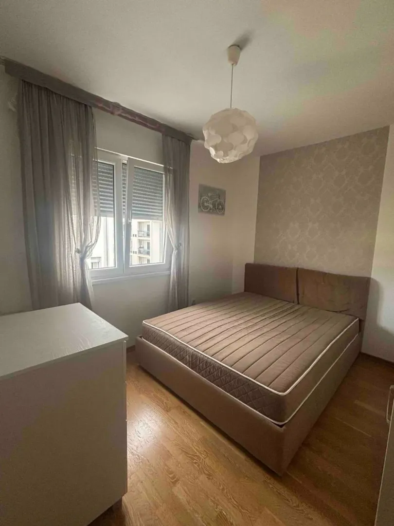 Furnished bedroom with a double bed and a window.